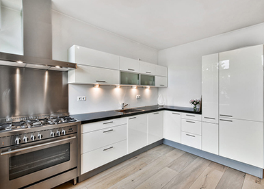 White and black L-shaped kitchen that optimises available space